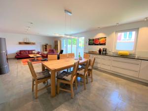 a kitchen and living room with a wooden table and chairs at Ferienhaus Corvin in Göhren