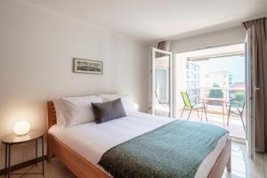 a bedroom with a bed and a balcony at Minusio Apartment by Quokka 360 - bright and modern flat with balcony in Minusio