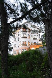 a large white building sitting on top of a hill at De La Sol Villa Dalat in Da Lat