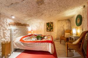a bedroom with a bed in a stone room at TerràThana in Saint-Aignan