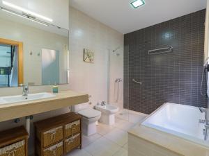 ein Badezimmer mit Badewanne, Toilette und Waschbecken in der Unterkunft Salobre private pool overlooking to the golf course- Pet friendly in San Bartolomé de Tirajana
