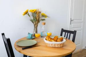 ノワイェ・シュル・シェールにあるLe Studio BILOBOUのパンのバスケットと花瓶を入れたテーブル