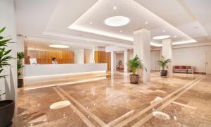 a lobby with a reception desk and potted plants at Hipotels Said in Cala Millor