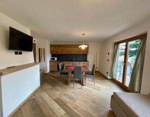 a kitchen and living room with a table and chairs at Casa Fabiolin in Daiano