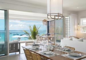 O'Biches by Horizon Holidays - Trou aux Biches في ترو أو بيش: غرفة طعام مع طاولة وإطلالة على المحيط