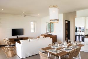 O'Biches by Horizon Holidays - Trou aux Biches في ترو أو بيش: غرفة معيشة مع أريكة بيضاء وطاولة