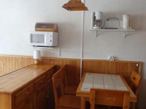 a small kitchen with a table and a microwave at Studio Valloire, 1 pièce, 3 personnes - FR-1-263-491 in Valloire