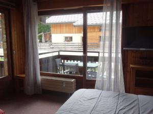 a bedroom with a window with a view of a balcony at Studio Valloire, 1 pièce, 3 personnes - FR-1-263-491 in Valloire