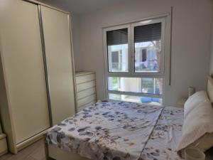 une chambre avec un lit et une fenêtre dans l'établissement Lovely 1-Bedroom Apartment at San Pietro Beach Front Resort, à Mullini i Danit