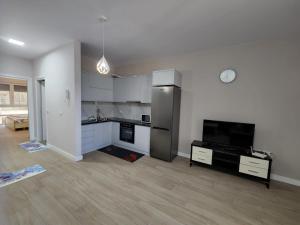 una cucina con frigorifero e una TV in camera di Lovely 1-Bedroom Apartment at San Pietro Beach Front Resort a Mullini i Danit