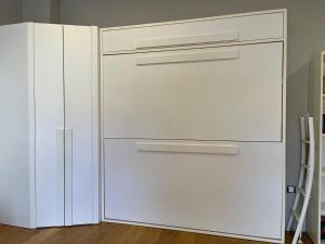 - un réfrigérateur blanc à côté d'une armoire blanche dans l'établissement InStudio Suances, à Suances