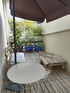 una mesa, sillas y una sombrilla en el patio en Bel appartement privatif en Perpiñán