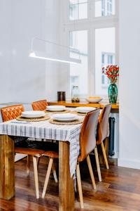 a dining room table with chairs and a vase of flowers at APARTEL LUX Plac Unii 72m2 in Warsaw