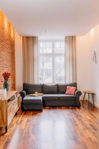a living room with a couch and a brick wall at APARTEL LUX Plac Unii 72m2 in Warsaw
