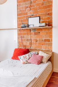 a bedroom with a brick wall and a bed with pillows at APARTEL LUX Plac Unii 72m2 in Warsaw