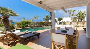 a patio with a table and chairs and a swimming pool at Villas Etnia in Binissafuller