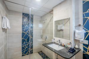 Un baño con lavabo y ducha en Hotel Akoya - HITECH City Hyderabad, en Hyderabad 26 fotos más