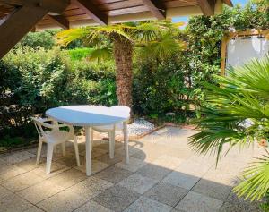 a table and a chair sitting on a patio at « La Palmeraie » Villa résidentielle avec piscine in La Palmyre