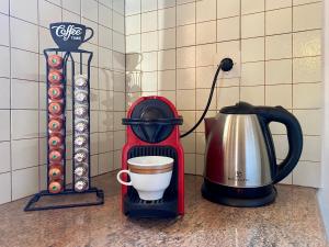 Olive Garden Home في Apesokárion: آلة صنع القهوة على منضدة مع كوب من القهوة