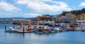 a group of boats docked in a harbor with buildings at Hotel Nuevo Parranda in Camariñas