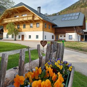 a wooden fence with flowers in front of a house at Auerhiasbauer in St. Wolfgang