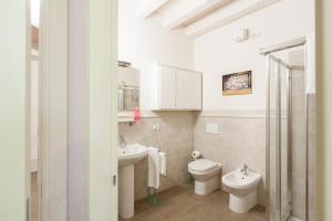 a bathroom with two sinks and a toilet and a shower at B&B CORTE SAN MICHELE Desenzano in San Martino della Battaglia +14 photos