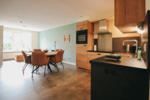 a kitchen and dining room with a table and chairs at Appartement met bedstee in Retranchement