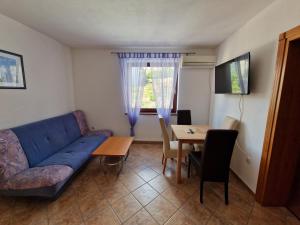 - un salon avec un canapé bleu et une table dans l'établissement Apartments Lacic 3, à Crikvenica