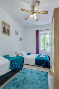 1 dormitorio con 2 camas y ventilador de techo en Buenas Noches en Split