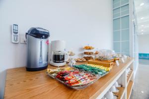 a counter with a coffee maker and food on it at Greenish Ranong Hotel in Ranong