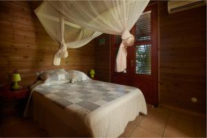 a bedroom with a bed in a wooden room at Villa Diodon in Deshaies