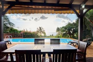 a table and chairs on a patio next to a pool at Villa Diodon in Deshaies