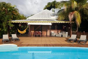 a resort with a swimming pool and a house at Villa Diodon in Deshaies