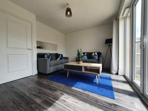 ein Wohnzimmer mit einem Sofa und einem Tisch in der Unterkunft Cheerful 4 - Tranquil Oasis Modern and Spacious Retreat 4-Bedroom with Private Parking and Serene Gardens in Luton