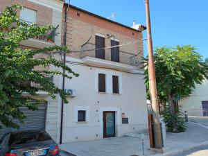 a white building with a car parked in front of it at Casa Rubino Holiday Home - 50mt dal centro in Troia