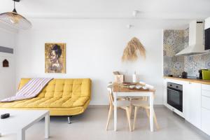 ロス・レアレホスにあるEl Castro Apartment, Amazing Ocean & Cliff Viewの黄色いソファとテーブルのあるリビングルーム