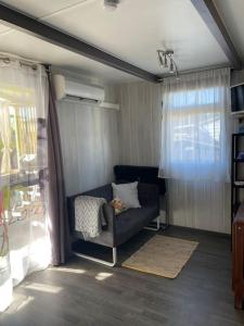 a living room with a blue couch and a window at Chalet à deux pas de la plage in Martigues