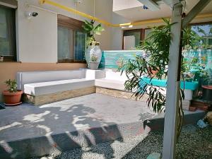 a patio with a white couch and some plants at Arcadia Apartament Mamaia Nord in Mamaia Sat/Năvodari