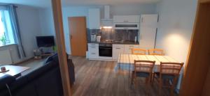 a living room with a table and chairs and a kitchen at Ferienwohnung Kröger in Rhede