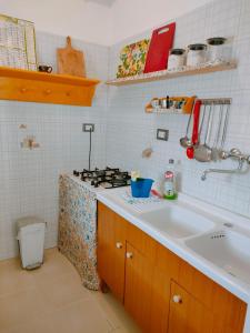 una cucina con lavandino e piano cottura di Appartamenti Cavataio 1 a Trappeto