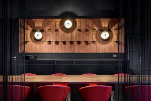 a conference room with a wooden table and red chairs at Laqua Vineyard in Terricciola