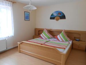 ein Schlafzimmer mit einem Holzbett mit Kissen darauf in der Unterkunft Ferienwohnung Kröger in Rhede