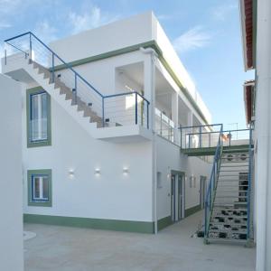 un bâtiment avec un escalier en colimaçon sur son côté dans l'établissement Corkoon Boutique Studios & Apartments - Duna Parque Group, à Vila Nova de Milfontes