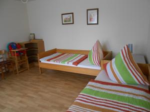 een kleine slaapkamer met een bed en een stoel bij Ferienwohnung Kröger in Rhede