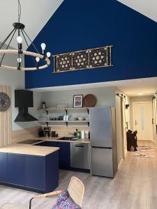 uma cozinha com uma parede azul e um frigorífico em Frafjord Apartments Thor em Dirdal