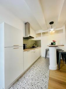 cocina blanca con armarios blancos y mesa en Superbe appartement T2 en plein centre d'Ajaccio, rue Fesch en Ajaccio
