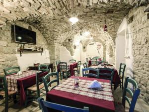ein Restaurant mit Tischen und Stühlen und einer Steinmauer in der Unterkunft I Templari di Alberona in Alberona