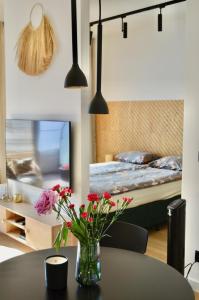 un vaso di fiori su un tavolo in una camera da letto di Plac Unii Gold Apartment a Gdynia