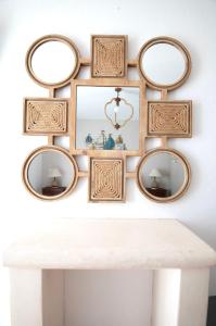 a group of mirrors on a wall above a white table at Astrio Suites in Livadi
