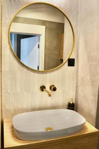 bagno con lavandino bianco e specchio di Plac Unii Gold Apartment a Gdynia